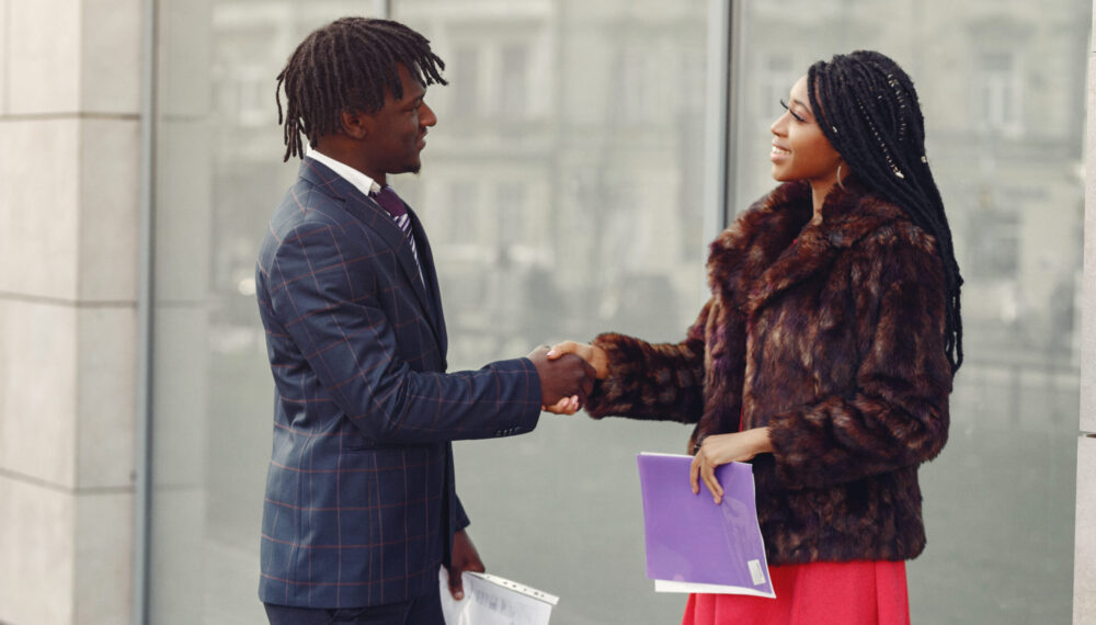 Black couple. Woman in a red dress. Man in a suit. Businesspeople.