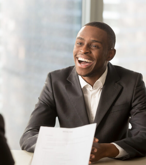 Happy black successful candidate getting hired, cheerful african applicant with beaming smile got a dream job in big company, dark-skinned businessman excited by great news, startupper found investor